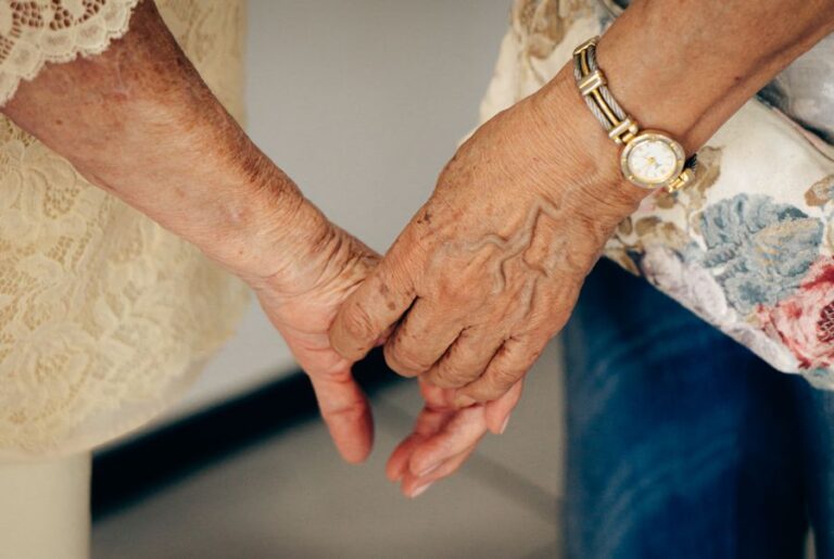 Mãos de pessoa idosa sendo acolhidas, simbolizando cuidado e companhia